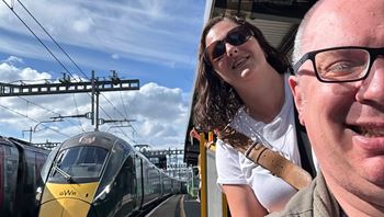 Carer and client stood next to a train, going on a business trip