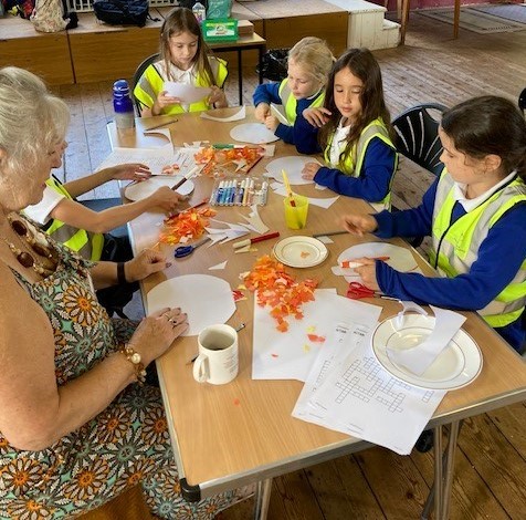 Older person doing crafts with a group of children