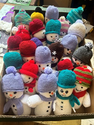 Box of knitted snowmen for community trail