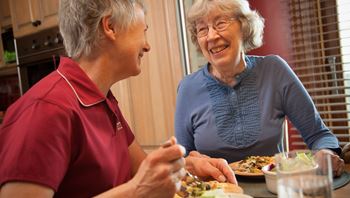 CareGiver and Client eating and smiling together