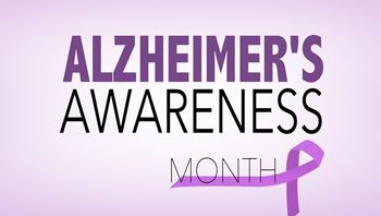 'Alzheimer's Awareness Month' sign with a purple background and a purple ribbon