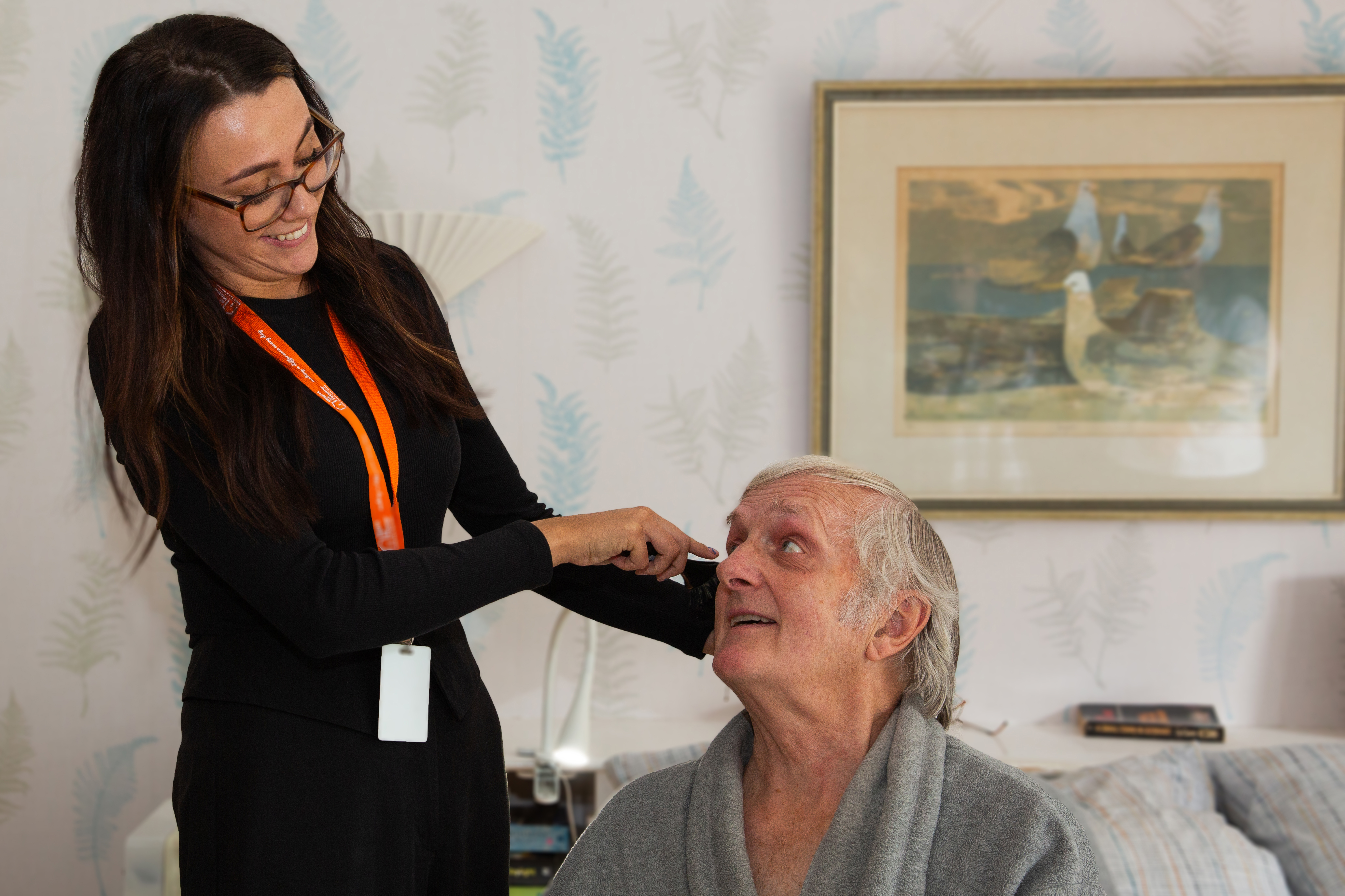Carer helping male client brush their hair