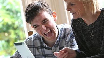 Male laughing with female using ipad