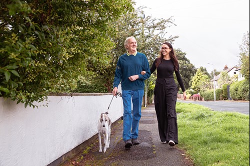 Carer and client walking a dog
